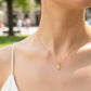 Cuello de modelo usando una cadena con un dije en forma de niña en oro amarillo de 18 quilates con cristales de Joyería Caracas.