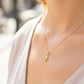 Cuello de modelo usando una cadena con un dije en forma de niño en oro amarillo de 18 quilates de Joyería Caracas.