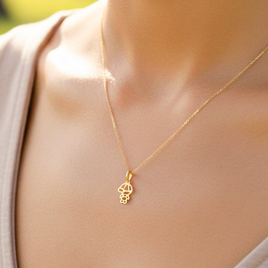 Cuello de modelo usando una cadena con un dije de la silueta de un niño en oro amarillo de 18 quilates de Joyería Caracas.