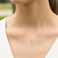 Cuello de modelo usando una cadena con un dije en forma de niño en oro amarillo de 18 quilates con cristales de Joyería Caracas.