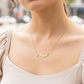 Cuello de modelo usando una cadena con un dije de nombre personalizado en oro amarillo de 18 quilates con cristales de Joyería Caracas.