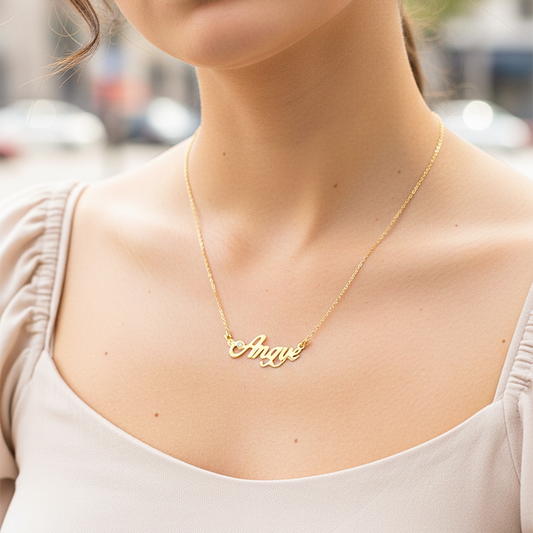 Cuello de modelo usando una cadena con un dije de nombre personalizado en oro amarillo de 18 quilates con cristales de Joyería Caracas.