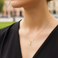 Cuello de modelo usando una cadena con un dije en forma de oso en oro amarillo de 18 quilates con cristales de Joyería Caracas.