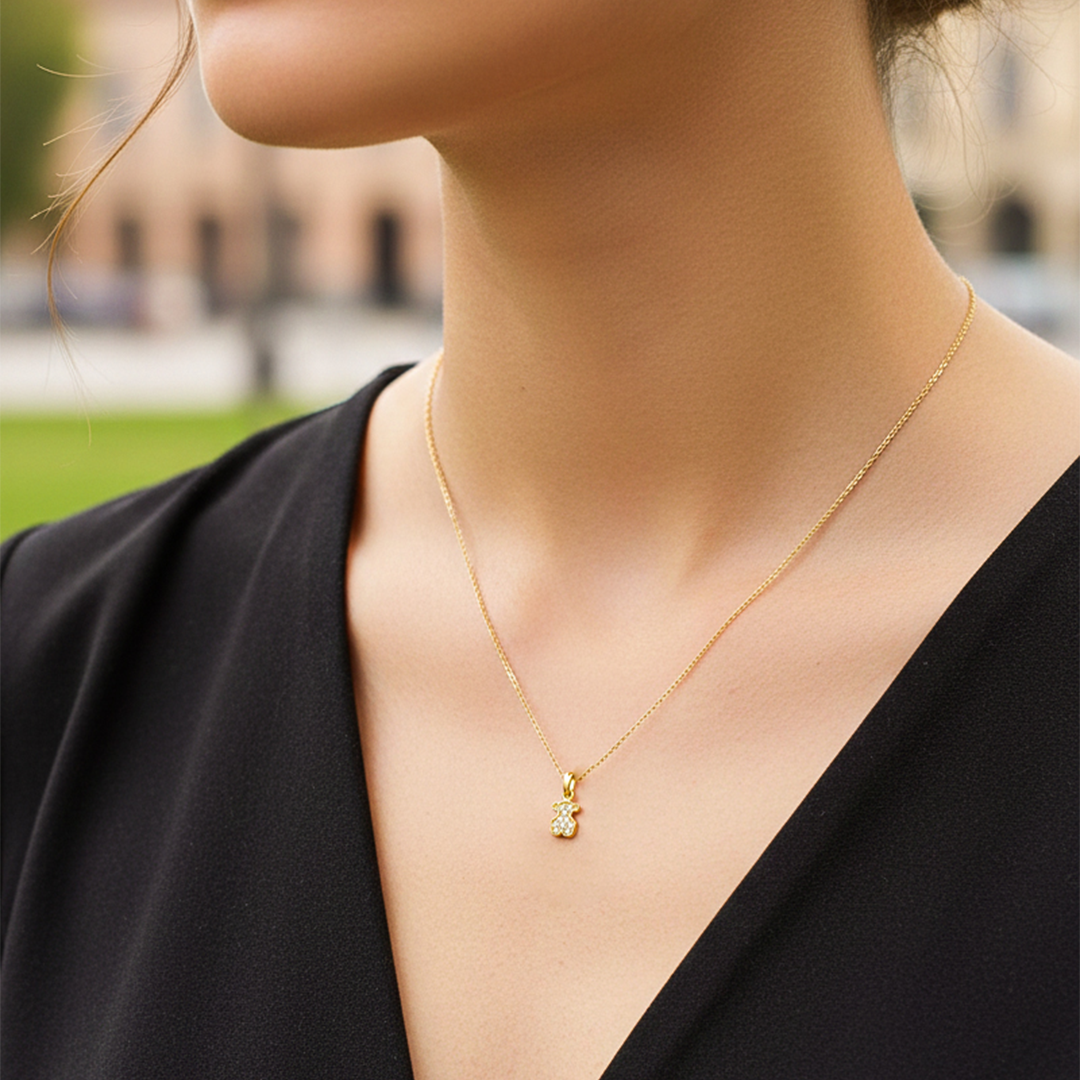 Cuello de modelo usando una cadena con un dije en forma de oso en oro amarillo de 18 quilates con cristales de Joyería Caracas.