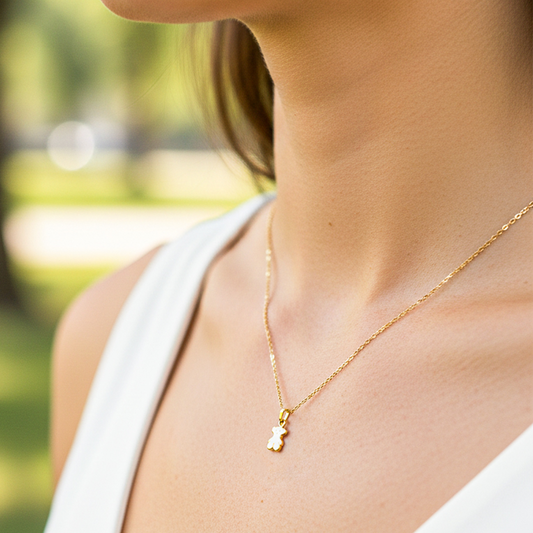 Cuello de modelo usando una cadena con un dije en forma de oso en oro amarillo de 18 quilates de Joyería Caracas.