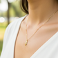 Cuello de modelo usando una cadena con un dije en forma de Papá en oro amarillo de 18 quilates de Joyería Caracas.