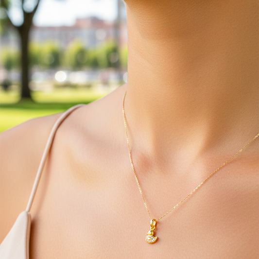 Cuello de modelo usando una cadena con un dije en forma de pato en oro amarillo de 18 quilates con cristales de Joyería Caracas.