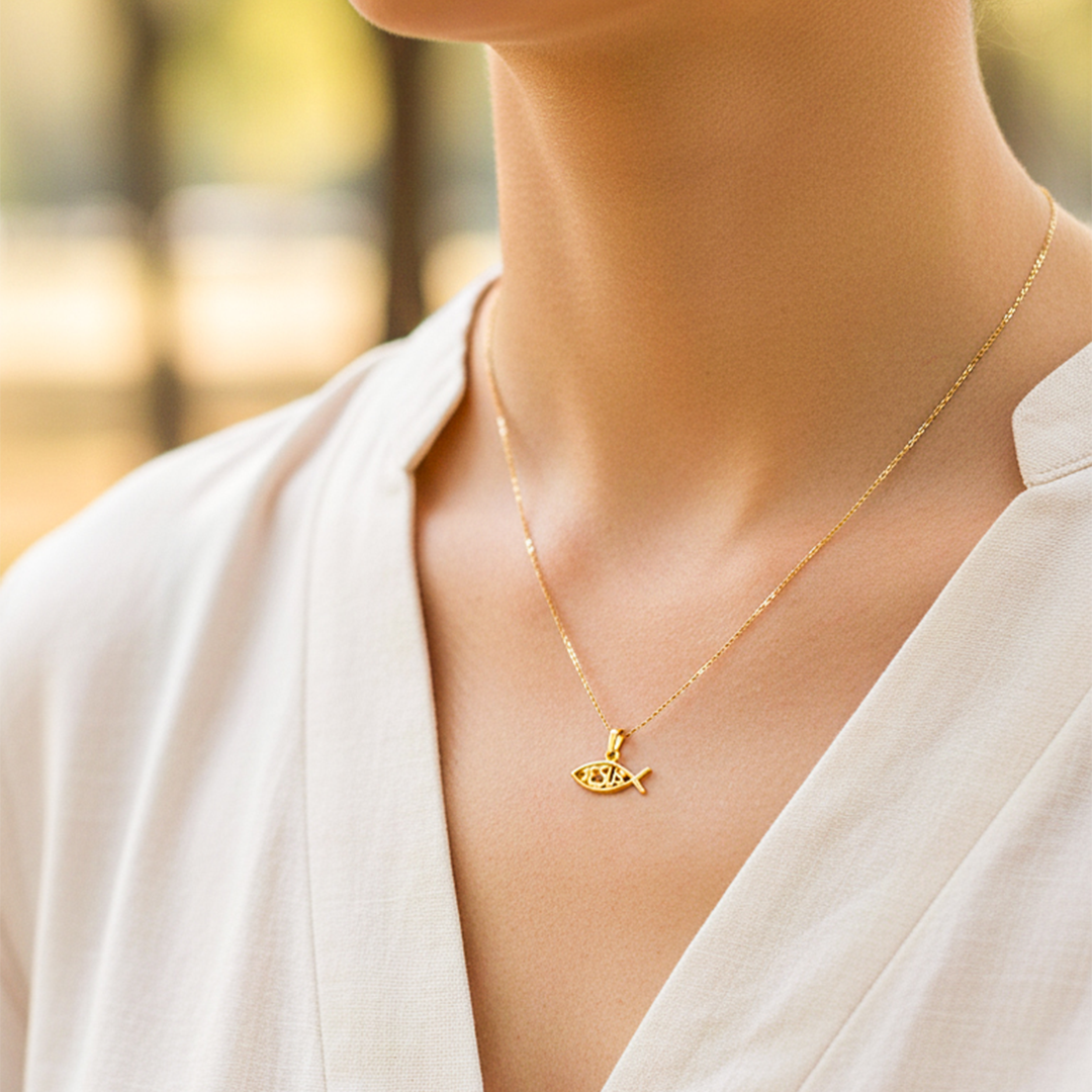 Cuello de modelo usando una cadena con un dije en forma de pez con la palabra Jesús en oro amarillo de 18 quilates de Joyería Caracas.