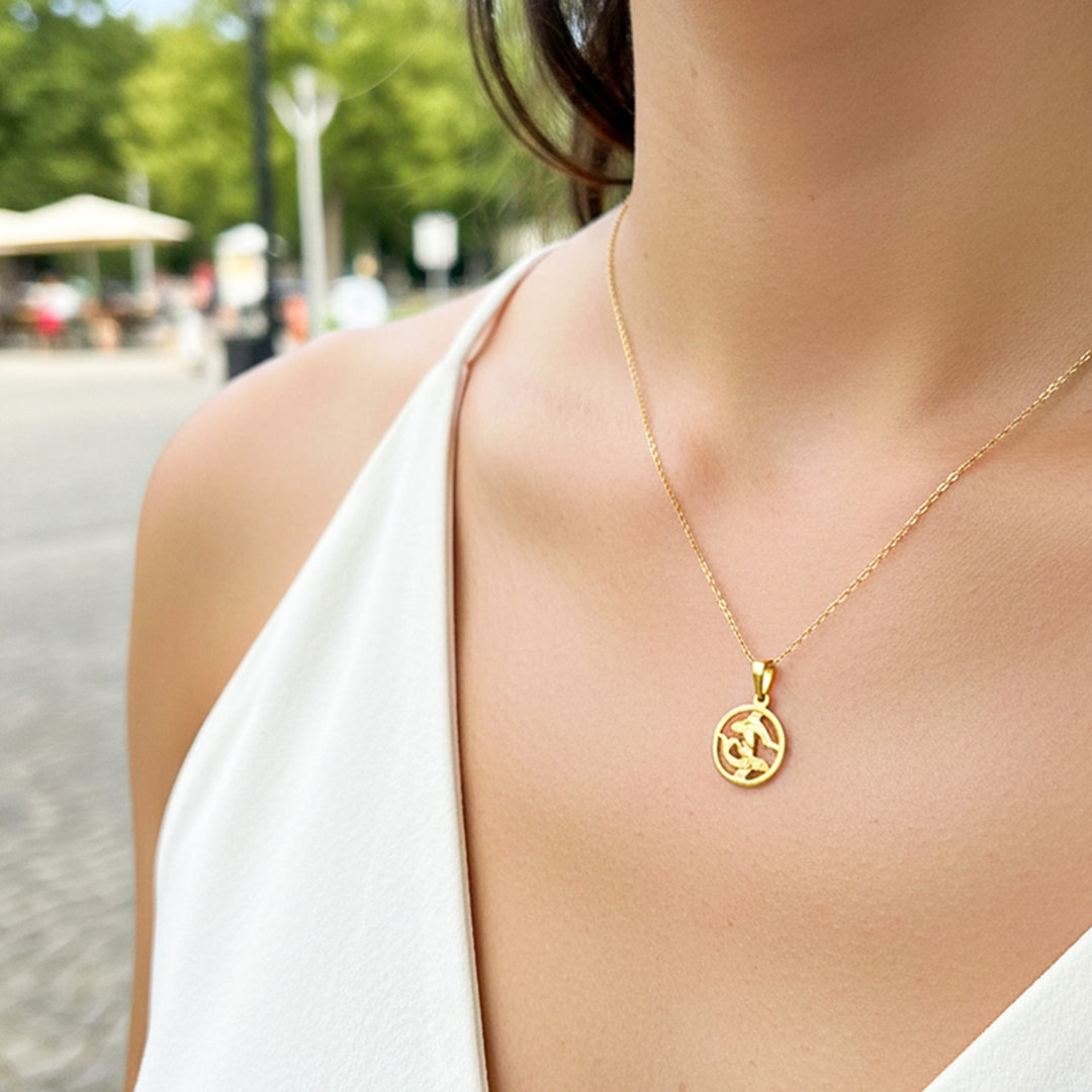 Cuello de modelo usando una cadena con un dije del signo zodiacal de Piscis en oro amarillo de 18 quilates de Joyería Caracas.