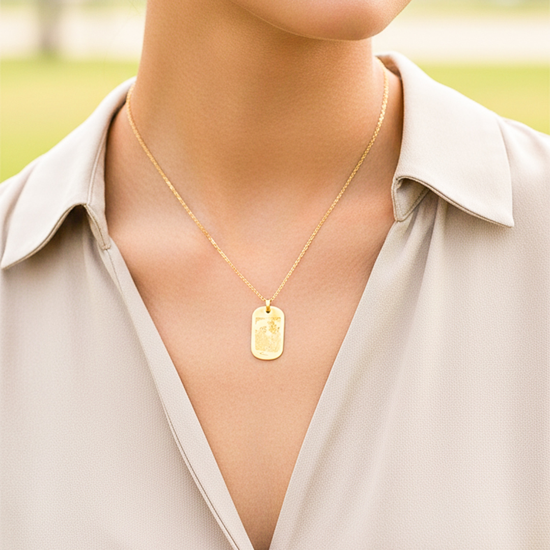 Cuello de modelo usando una cadena con un dije en forma de placa con fotograbado en oro amarillo de 18 quilates de Joyería Caracas.