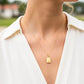 Cuello de modelo usando una cadena con un dije en forma de placa de colmena en oro amarillo de 18 quilates de Joyería Caracas.