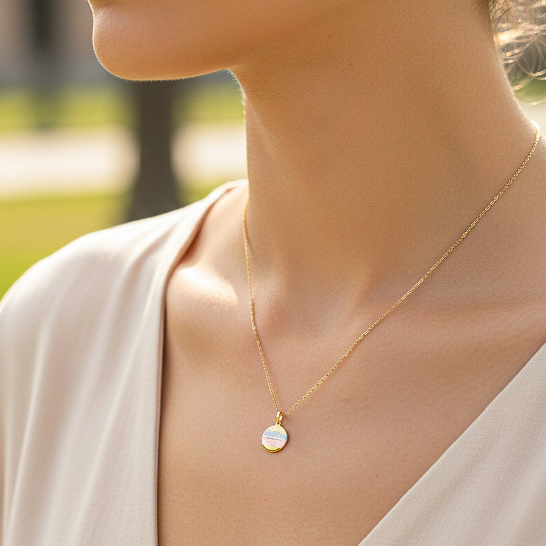 Cuello de modelo usando una cadena con un dije de placa en 3 oros de 18 quilates de Joyería Caracas.