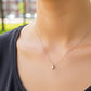 Cuello de modelo usando una cadena con un dije en forma rectangular en oro blanco de 18 quilates con cristal de Joyería Caracas.