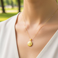Cuello de modelo usando una cadena con un dije en forma de relicario con letra personalizada en oro amarillo de 18 quilates de Joyería Caracas.