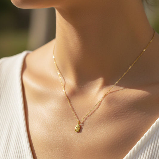 Cuello de modelo usando una cadena con un dije del rostro de Jesús en oro amarillo de 18 quilates de Joyería Caracas.