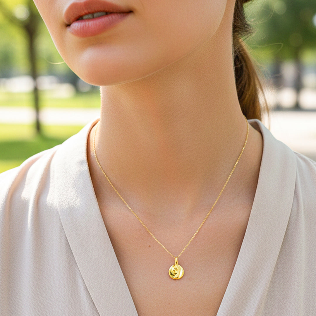 Cuello de modelo usando una cadena con un dije en forma de placa del Rostro de la Virgen en oro amarillo de 18 quilates de Joyería Caracas.