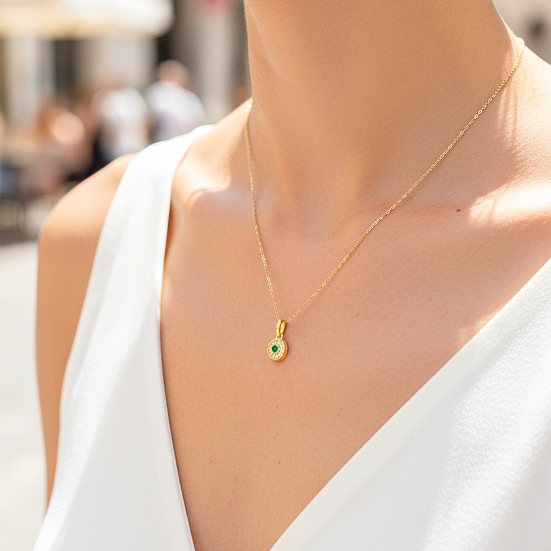 Cuello de modelo usando una cadena con un dije en forma de rueda en oro amarillo de 18 quilates con cristales de Joyería Caracas.