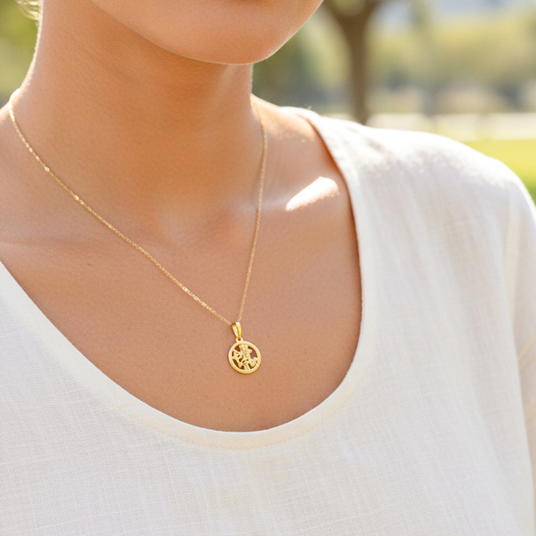 Cuello de modelo usando una cadena con un dije del signo zodiacal de Sagitario en oro amarillo de 18 quilates de Joyería Caracas.