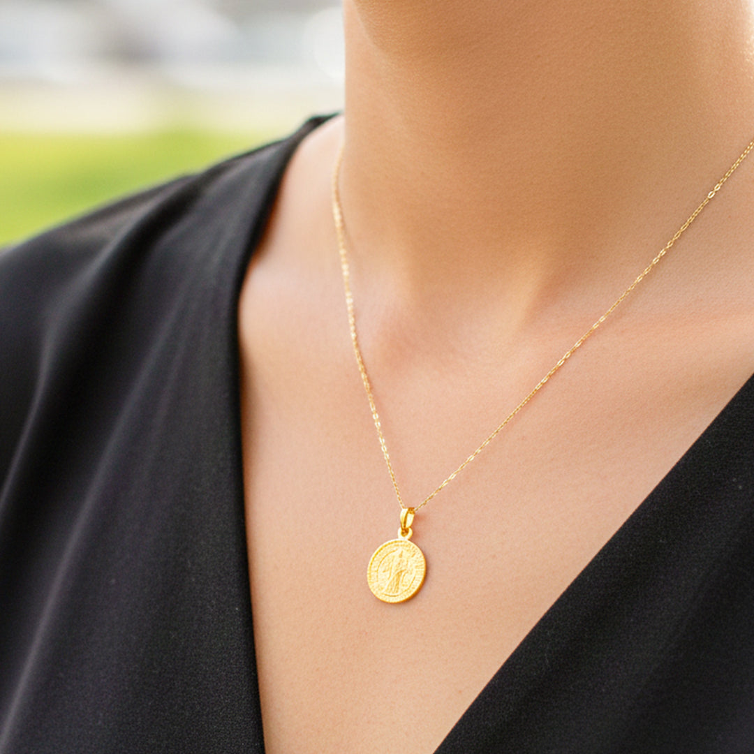 Cuello de modelo usando una cadena con un dije de San Benito en oro amarillo de 18 quilates de Joyería Caracas.