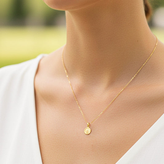 Cuello de modelo usando una cadena con un dije de San Benito en oro amarillo de 18 quilates de Joyería Caracas.