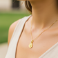 Cuello de modelo usando una cadena con un dije en forma de San Benito en oro amarillo de 18 quilates de Joyería Caracas.