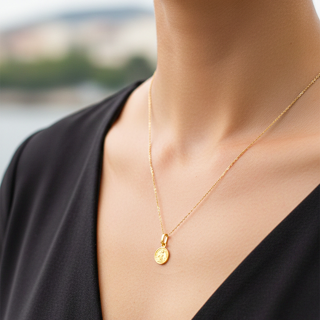 Cuello de modelo usando una cadena con un dije de San Benito oro amarillo de 18 quilates de Joyería Caracas.