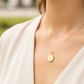 Cuello de modelo usando una cadena con un dije en forma de San Benito en oro amarillo de 18 quilates con cristales de Joyería Caracas.