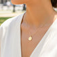 Cuello de modelo usando una cadena con un dije en forma de San Benito en oro amarillo de 18 quilates con cristales de Joyería Caracas.