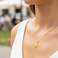 Cuello de modelo usando una cadena con un dije en forma de San Benito diamantado en oro amarillo de 18 quilates de Joyería Caracas.