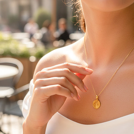 Cuello de modelo usando una cadena con un dije de San Benito en oro amarillo de 18 quilates de Joyería Caracas.