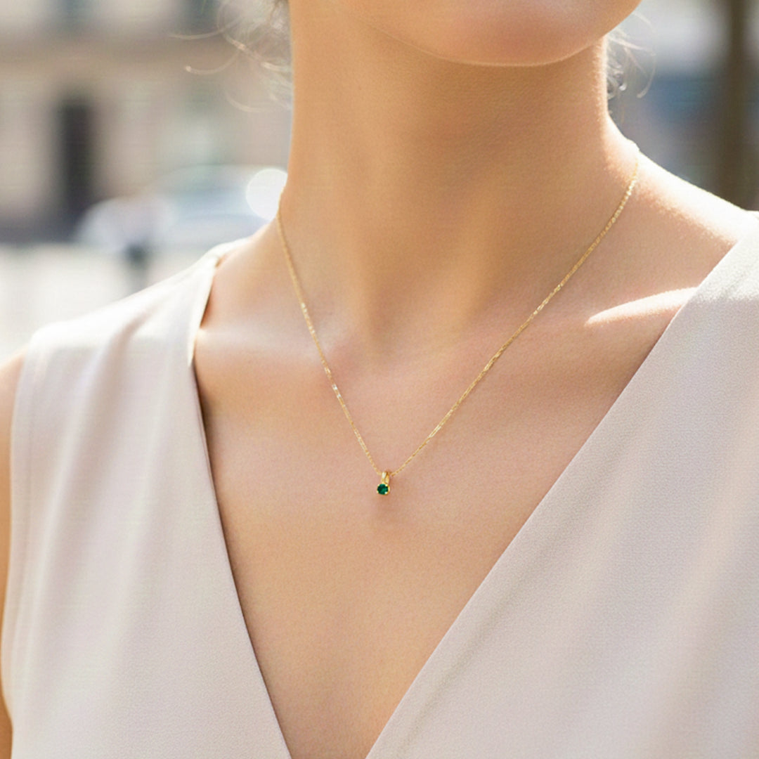 Cuello de modelo usando una cadena con un dije en forma de corazón en oro amarillo de 18 quilates con cristal redondo de Joyería Caracas.