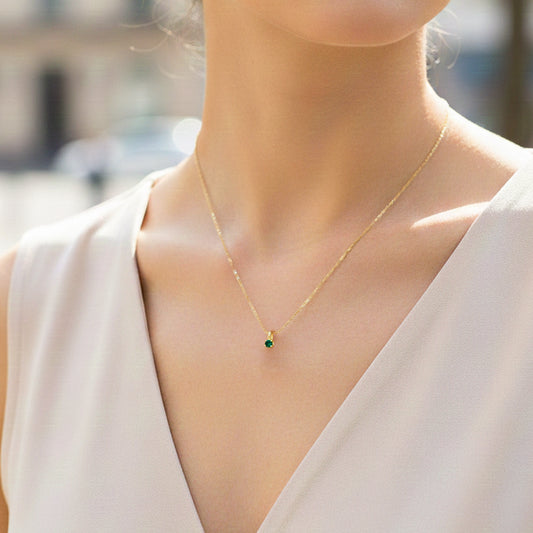 Cuello de modelo usando una cadena con un dije en forma de corazón en oro amarillo de 18 quilates con cristal redondo de Joyería Caracas.