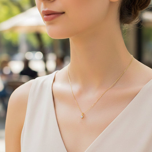 Cuello de modelo usando una cadena con un dije en oro amarillo de 18 quilates con cristal redondo de Joyería Caracas.