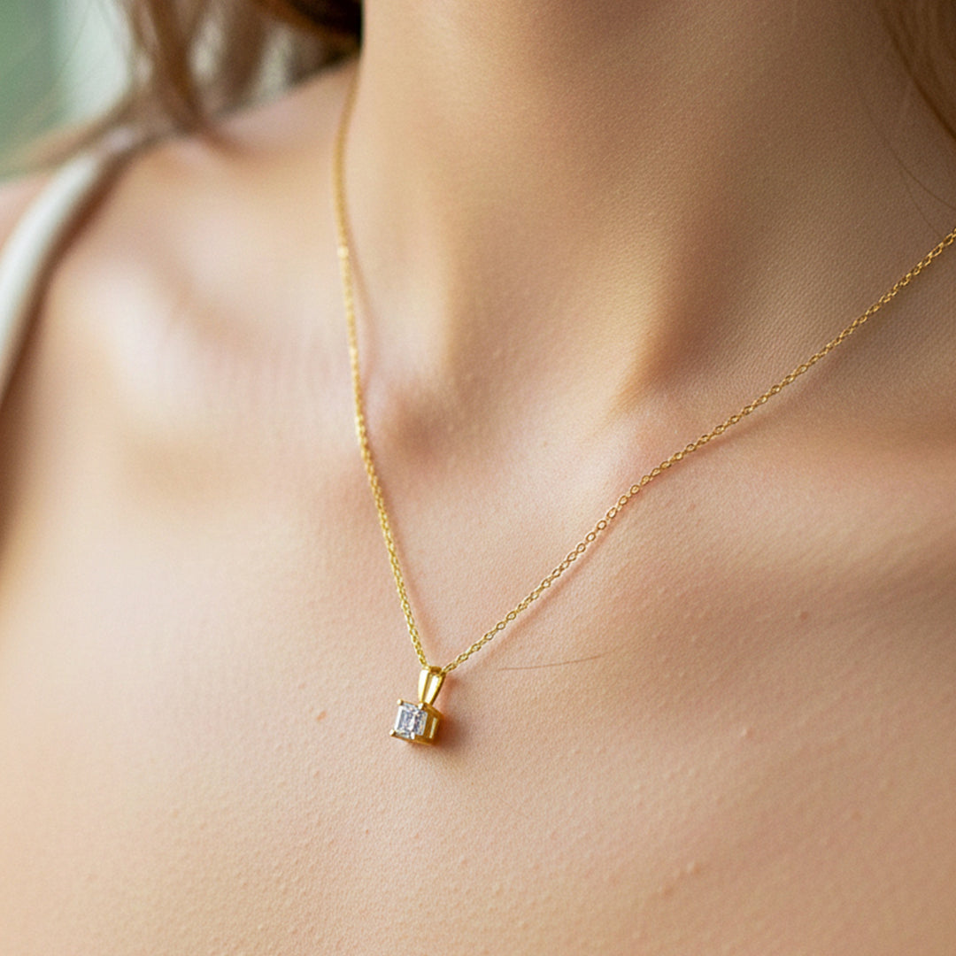 Cuello de modelo usando una cadena con un dije en oro amarillo de 18 quilates con cristal en corte cuadrado de Joyería Caracas.