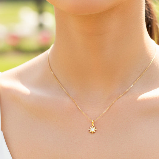 Cuello de modelo usando una cadena con un dije en forma de sol en oro amarillo de 18 quilates con cristales de Joyería Caracas.