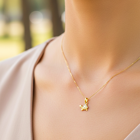 Cuello de modelo usando una cadena con un dije en forma de tortuga en oro amarillo de 18 quilates con cristales de Joyería Caracas.