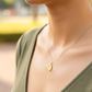 Cuello de modelo usando una cadena con un dije en forma de la Virgen del Carmen en oro amarillo de 18 quilates con cristales de Joyería Caracas.