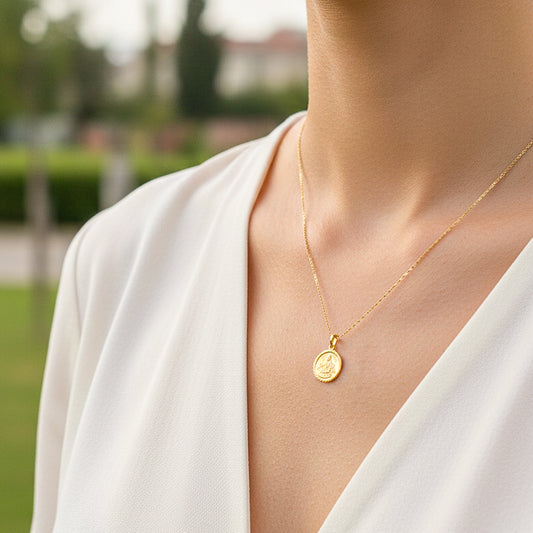 Cuello de modelo usando una cadena con un dije redondo de la Virgen de la Caridad en oro amarillo de 18 quilates de Joyería Caracas.
