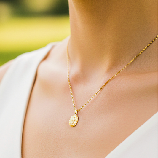Cuello de modelo usando una cadena con un dije en forma de la Virgen Milagrosa en oro amarillo de 18 quilates de Joyería Caracas.