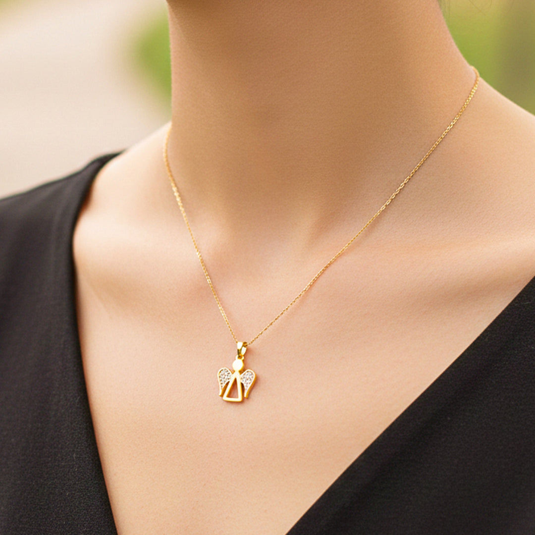 Cuello de modelo usando una cadena con un dije en forma de angelito en oro amarillo de 18 quilates con cristales de Joyería Caracas.
