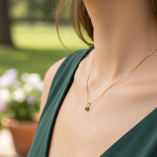 Cuello de modelo usando una cadena con un dije en oro amarillo de 18 quilates con Esmeralda de Joyería Caracas.