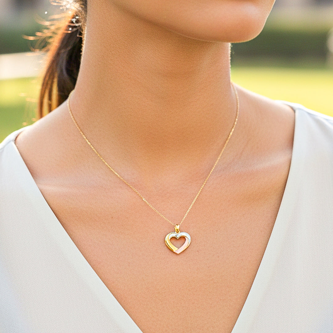 Cuello de modelo usando una cadena con un dije en forma de corazón en 3 oros de 18 quilates de Joyería Caracas.