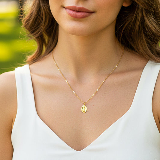 Cuello de modelo usando una cadena con un dije de placa ovalada con el rostro de la Virgen en oro amarillo de 18 quilates de Joyería Caracas.