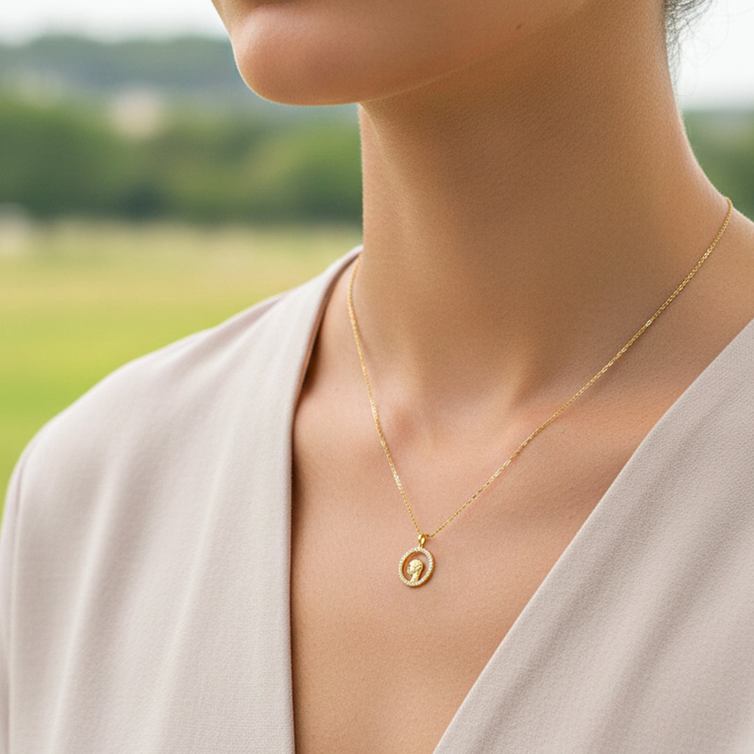 Cuello de modelo usando una cadena con un dije del rostro de la Virgen en oro amarillo de 18 quilates con cristales de Joyería Caracas.