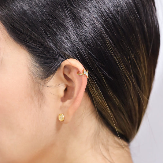 Oreja de mujer con earcuff en forma de rayo en oro amarillo de 18 quilates con cristales de color blanco, hecho en Joyería Caracas. 