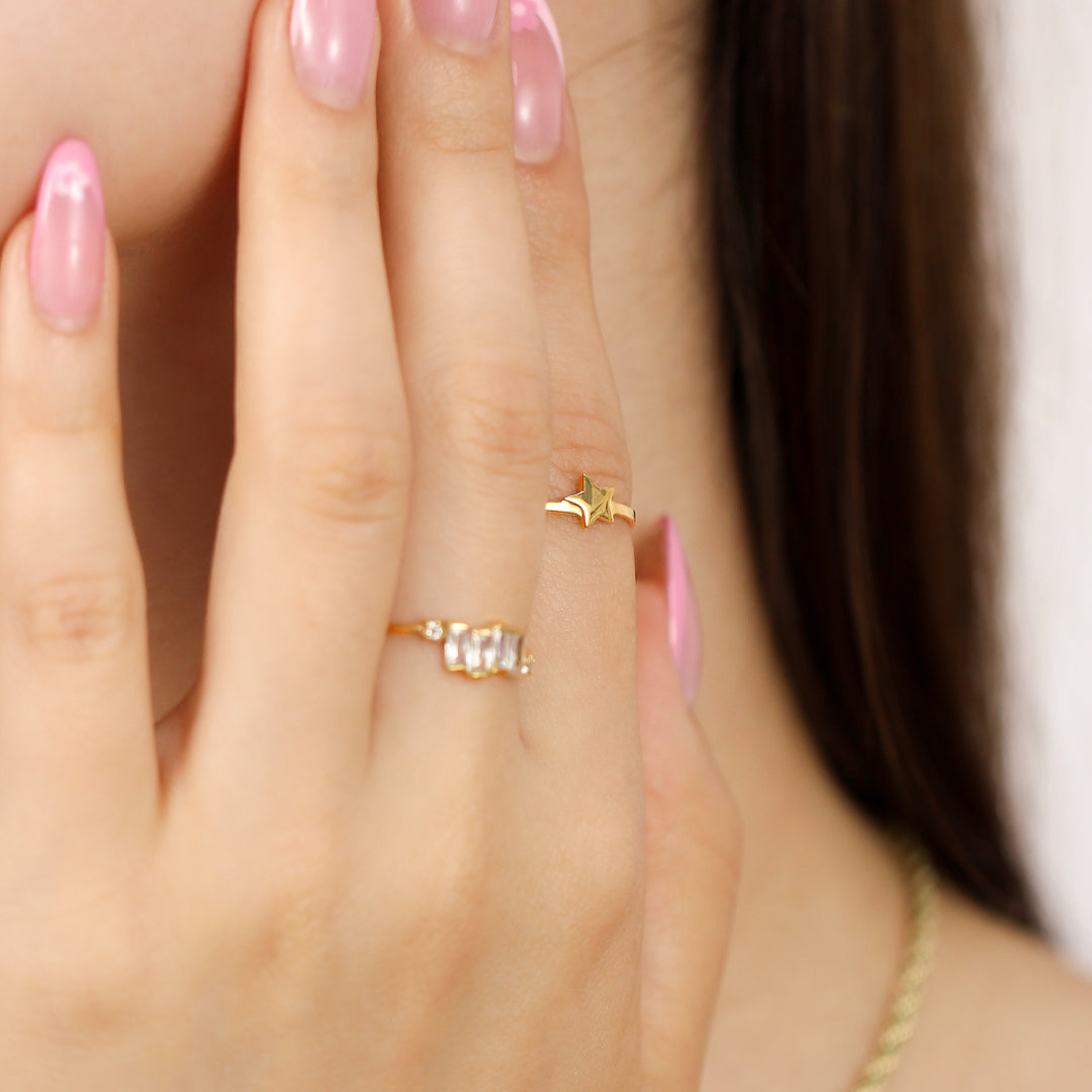 Mano de mujer usando anillo con estrella en el centro en oro amarillo de 18 quilates, hecho en Joyería Caracas. 
