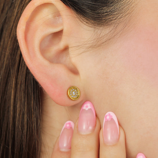 Oreja de mujer con topito en forma circular en oro amarillo de 18 quilates con cristales de color blanco, hechos en Joyería Caracas. 