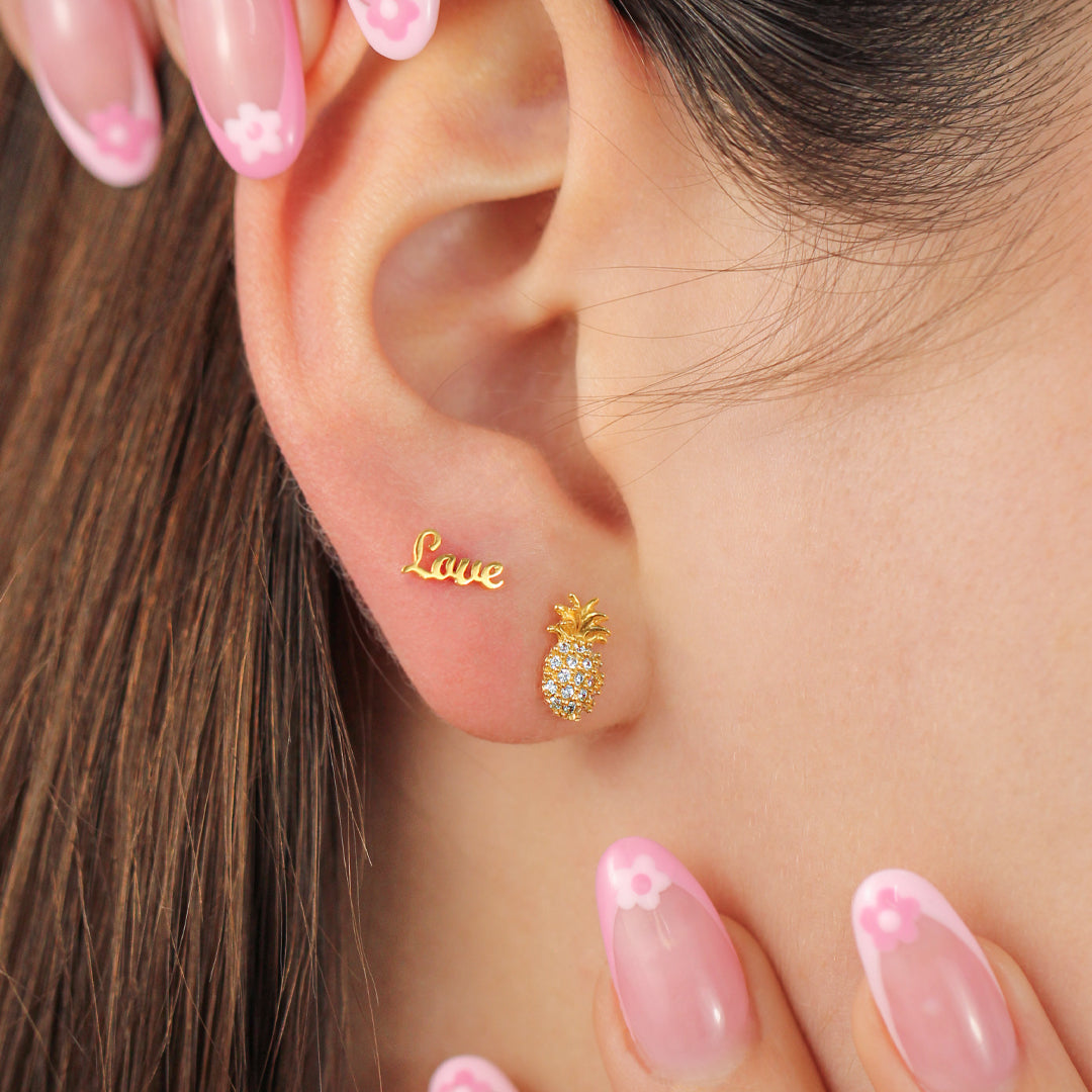 Oreja de mujer con topito de la palabra love en oro amarillo de 18 quilates, hechos en Joyería Caracas. 