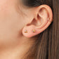 Oreja de mujer con topito en forma de flor de loto en oro blanco, rosa y amarillo de 18 quilates con cristal de color blanco en el centro, hechos en Joyería Caracas.