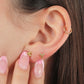 Oreja de mujer con topito en forma de flor de loto liso en oro amarillo de 18 quilates, hechos en Joyería Caracas. 